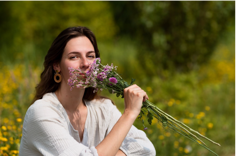 Жена на поляна с букет от билки