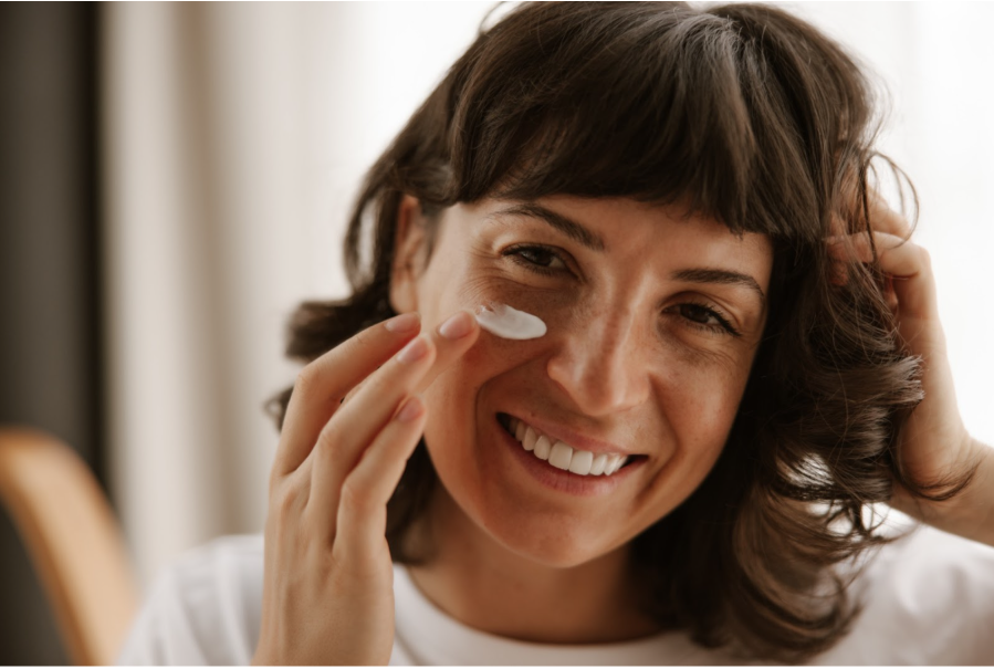 Жена нанася слънцезащитен крем с подходящ SPF на лицето си