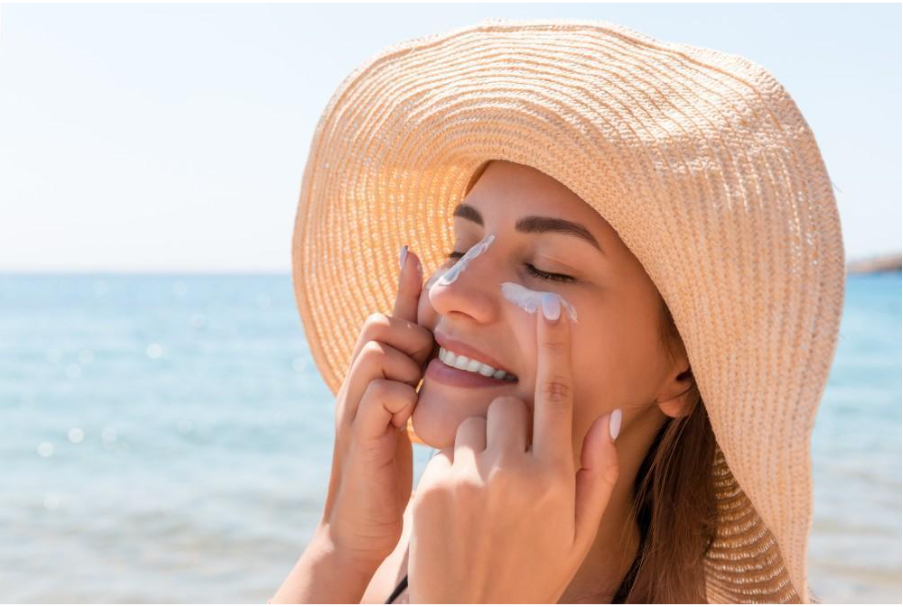 Жена нанася крем на лицето си