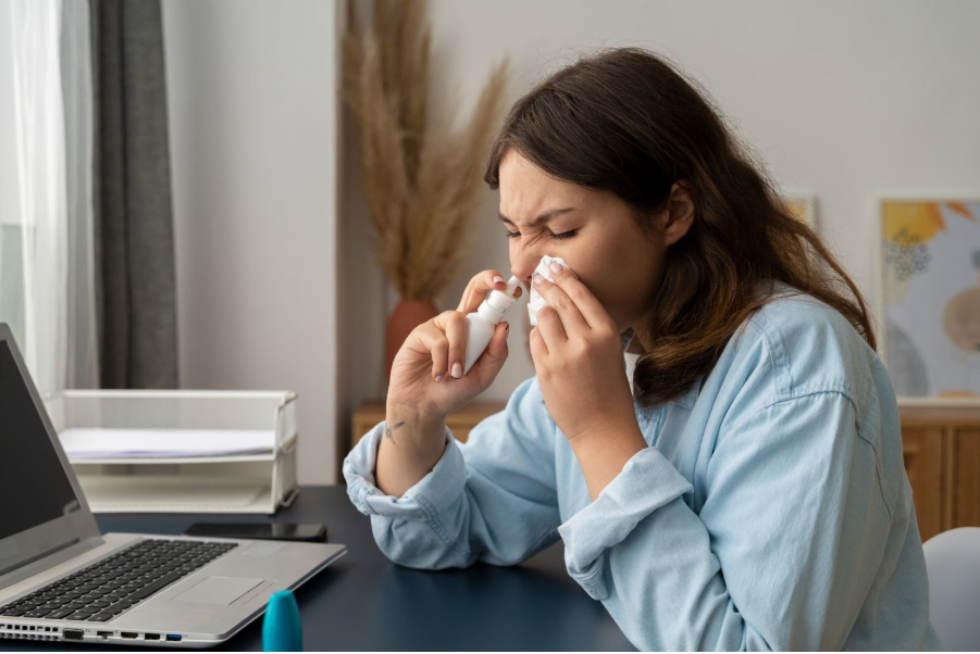 Жена с бактерия в носа си слага капки.