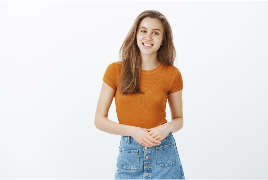 Усмихната жена с оранжева блуза и дънки