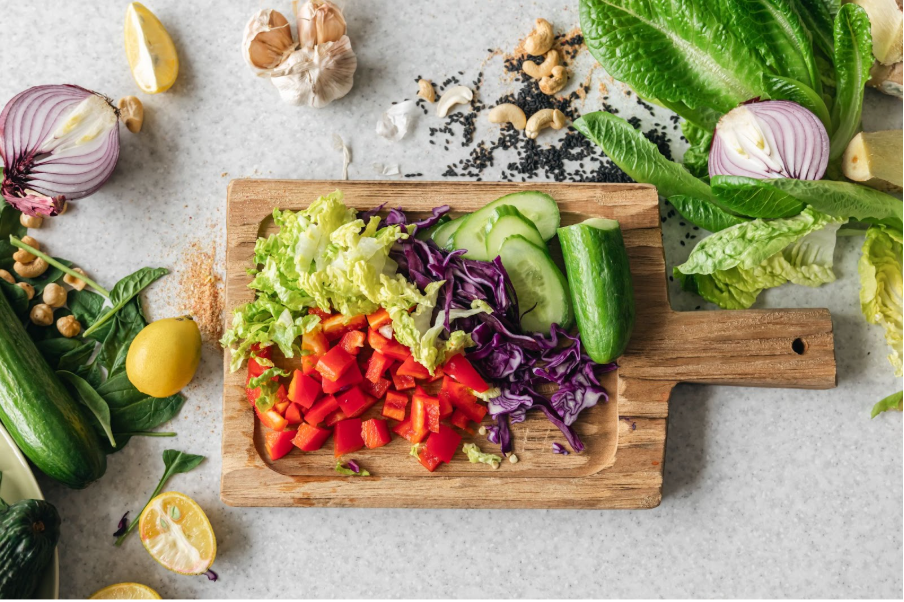 различни зеленчуци върху дървена дъска, подходящи при висок холестерол