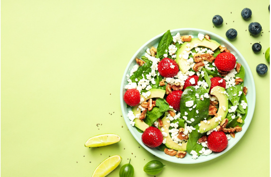 Чиния с ягоди, зеленолистни зеленчуци и орехи.