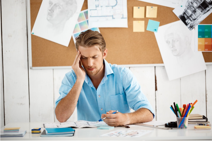 Мъж пише в тетрадка на работното си място