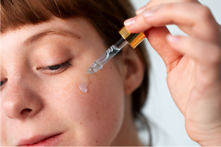 Жена нанася серум върху лицето си