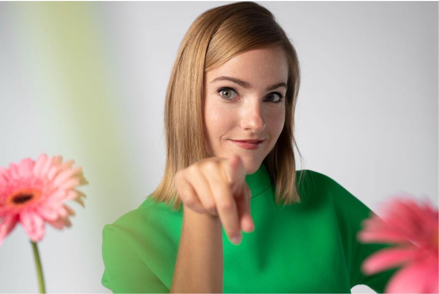 Жена облечена в зелена блуза сочи към читателя
